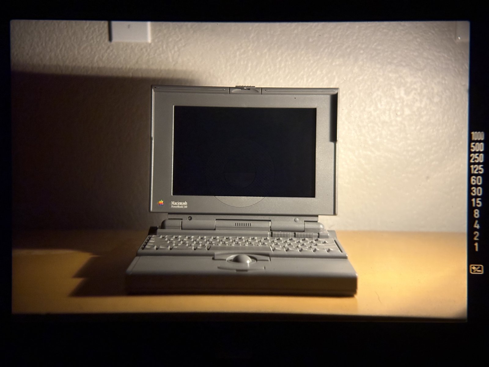 A photograph of the PowerBook 140 displayed on a screen.