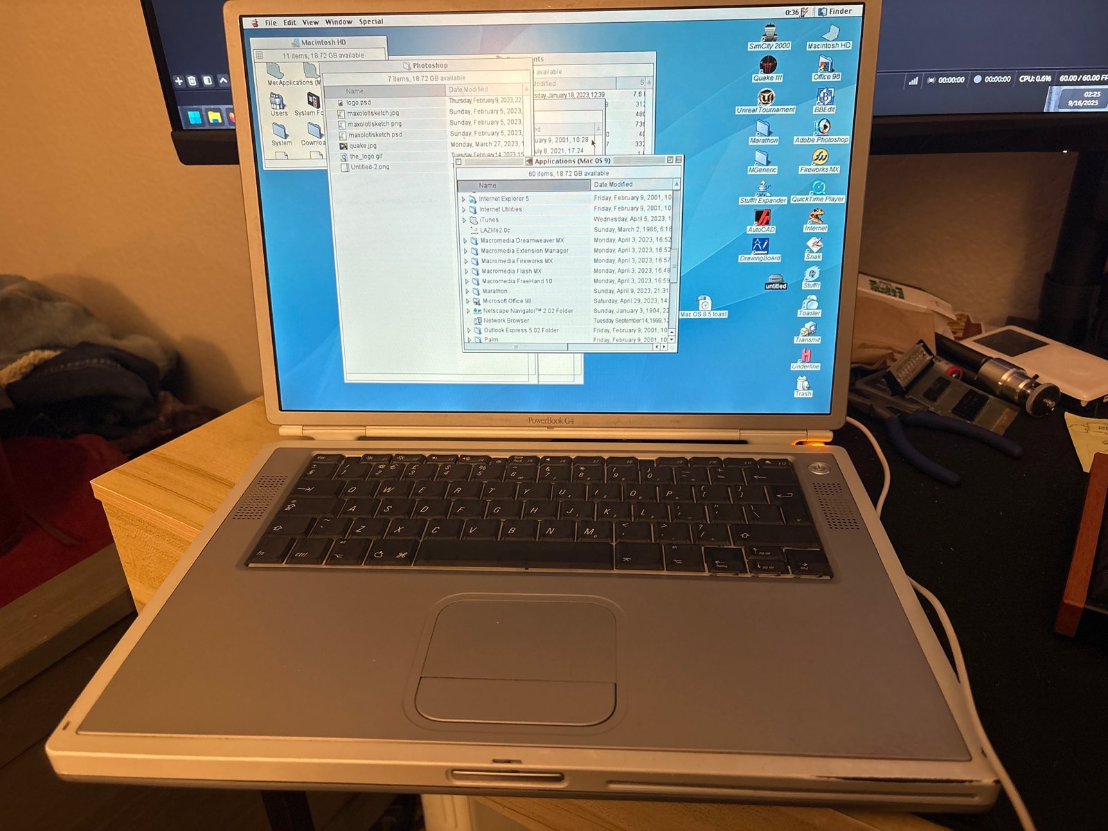 The titanium PowerBook displaying a Mac OS desktop.
